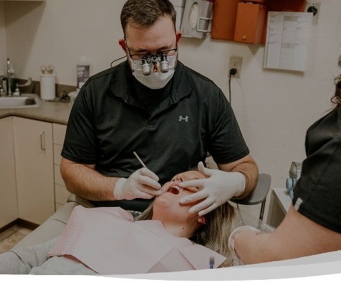dentist working on patient's smile with dental assistant